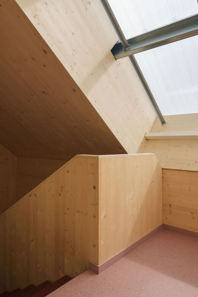 Upper stair landing with angled plywood ceiling and translucent polycarbonate wall panels