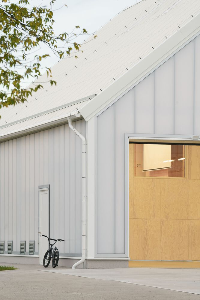 Corner of the corrugated metal facade with a bicycle leaning beside the entry door