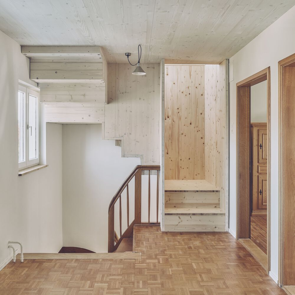 Interior hallway with exposed softwood ceiling, herringbone parquet flooring, wooden staircase and curved timber handrail