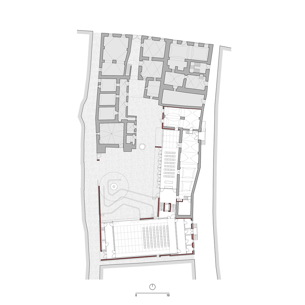 Floor plan drawing showing interior rooms and a courtyard with circular water feature and seating grid