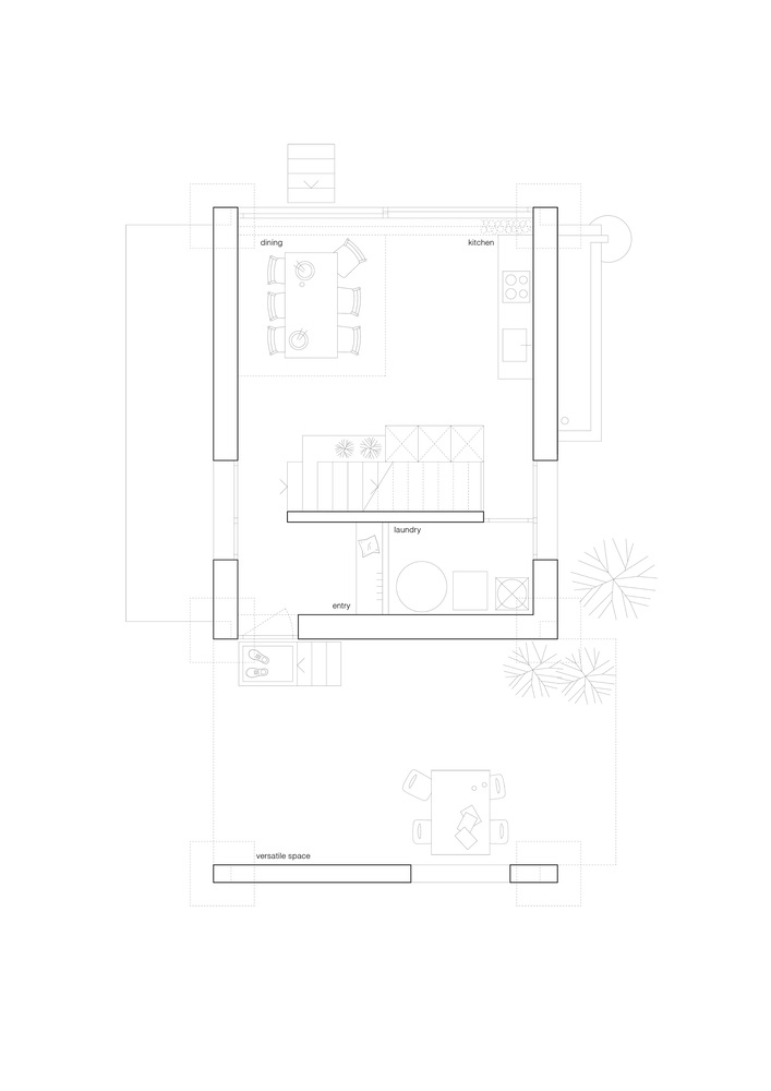 Ground floor plan drawing showing dining and kitchen spaces flanked by symmetrical vertical circulation elements