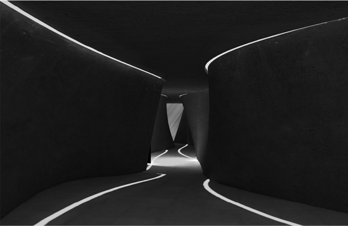 Converging passageways with linear ceiling slots bringing daylight into the dark interior