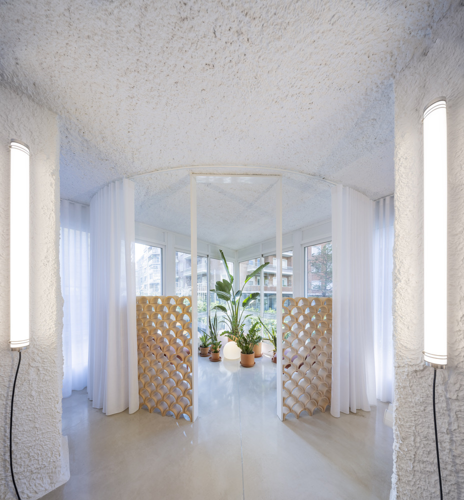 Textured white columns framing a view through latticed timber screens with potted plants between them