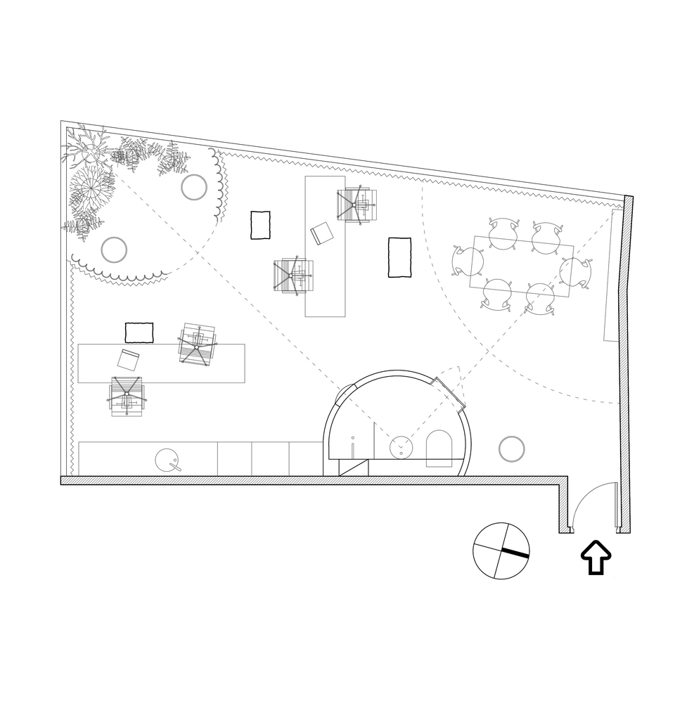 Floor plan drawing showing an open workspace with furniture layout and curved partition wall