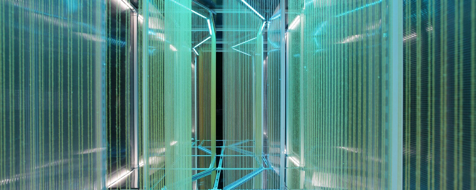 An ethereal play of light and color weaving through transparent strands, creating a dynamic, immersive architectural experience.