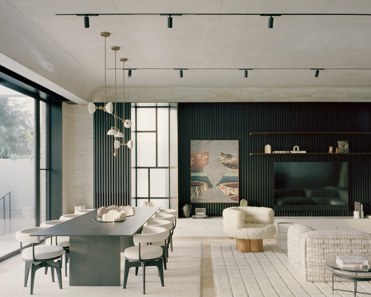 Open-plan living and dining space with dark vertical slat wall and pale timber flooring