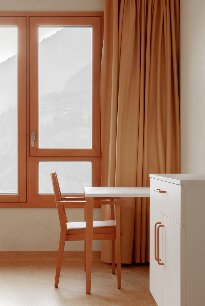 Interior room corner with timber framed glazed door overlooking misty mountains and matching curtains