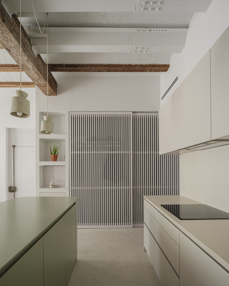 Kitchen passage with ribbed sliding panels, exposed timber beams, and open shelving with a potted plant