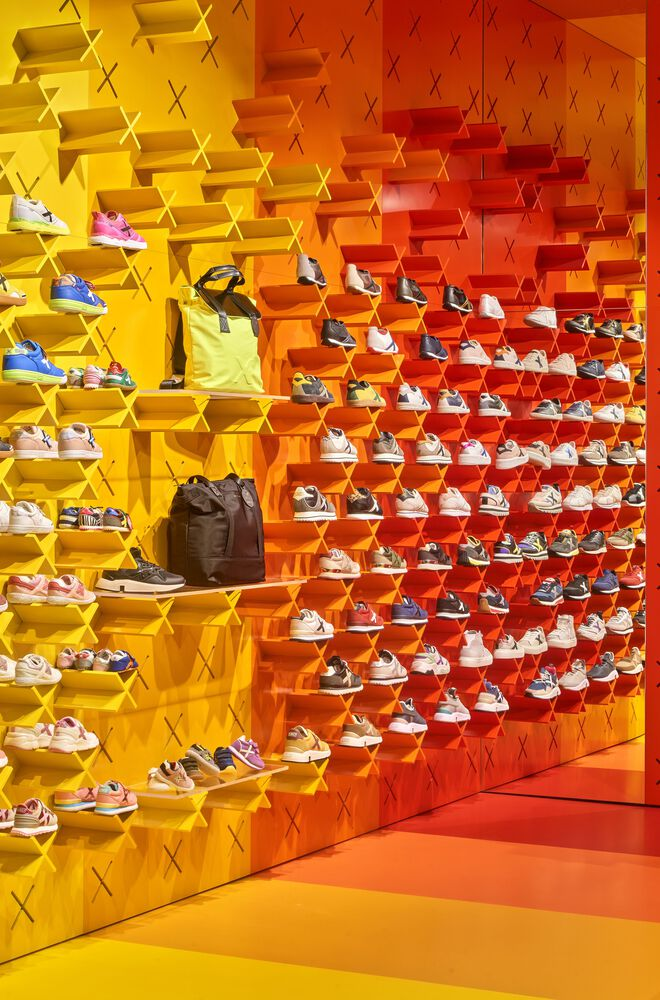 Close view of stepped box shelving system displaying sneakers across yellow, orange and red gradient zones
