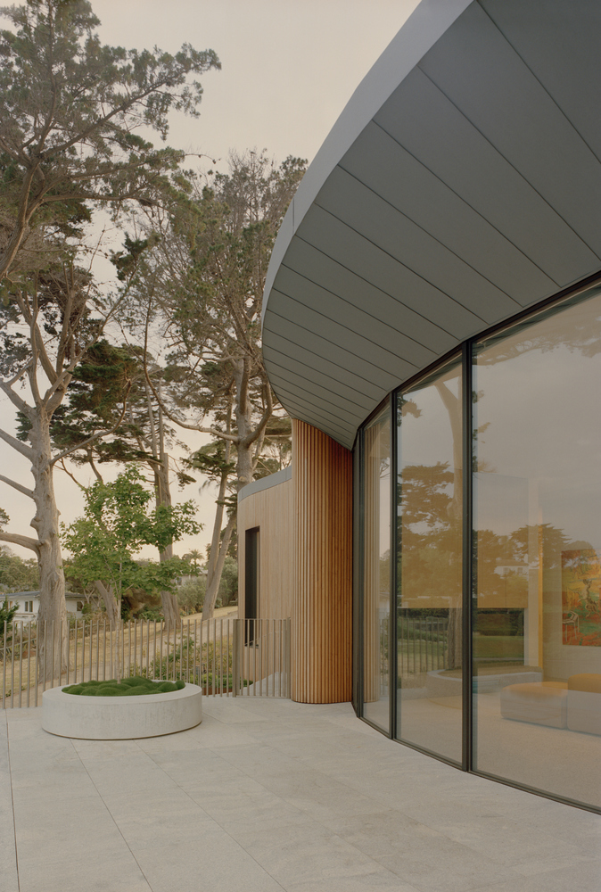 Exterior corner showing panelled soffit overhang and timber column beside circular planter