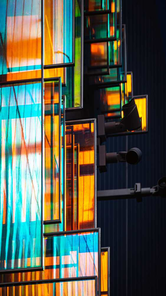 Detail of the dichroic glass panels and external steel staircase illuminated against darkness