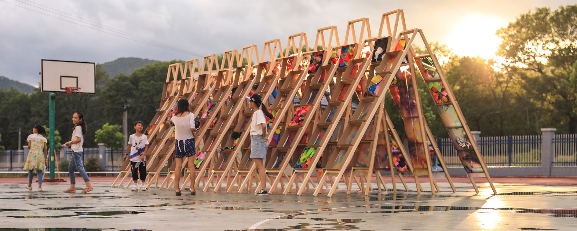 Children engaging in creative play and design with the vibrant wooden ladder pavilion built as part of the Hi Ladders High project.