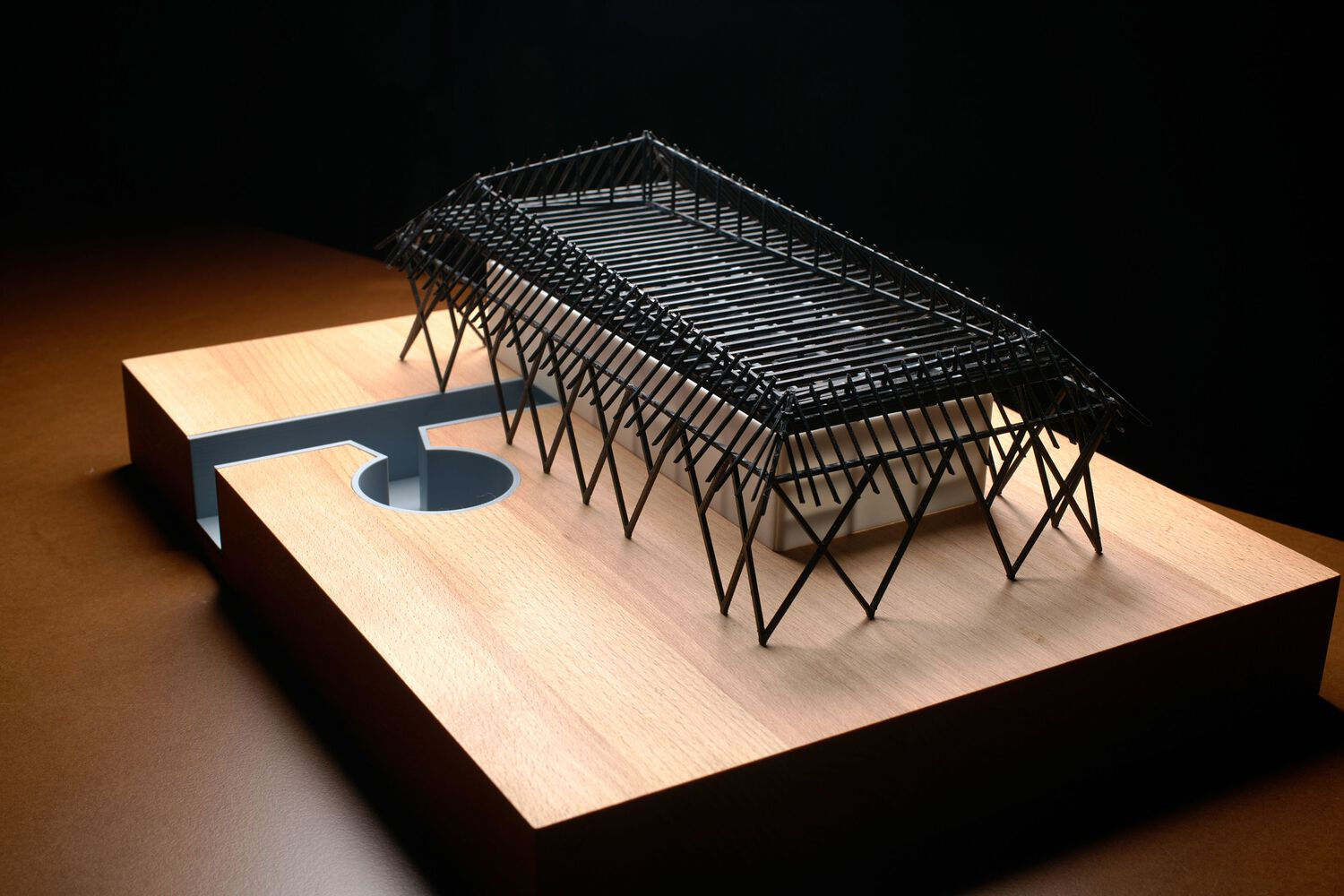 Side view of the architectural model highlighting the repetitive diagonal bracing and translucent roof panels