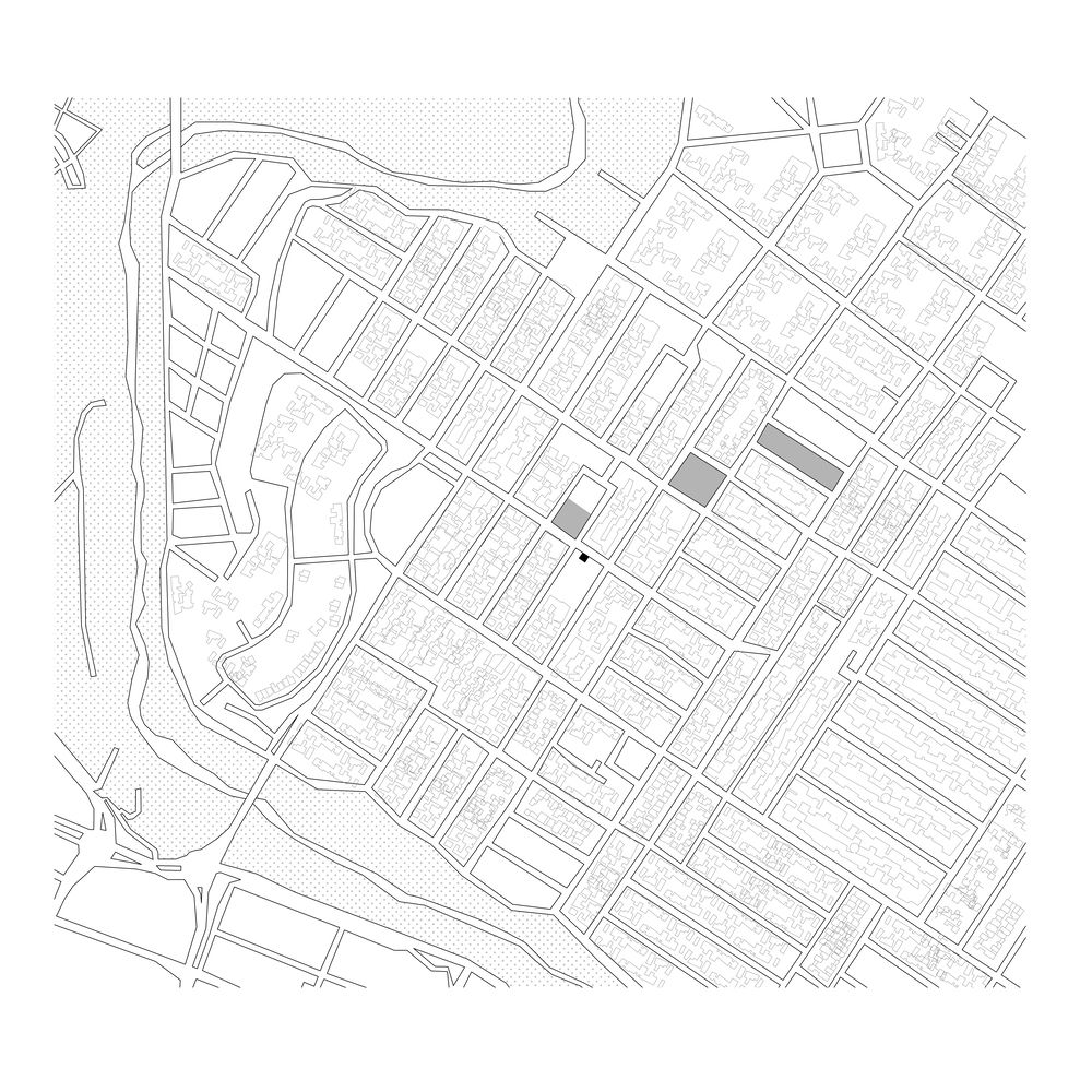 Site plan drawing showing the building footprint within a gridded urban block near a waterfront