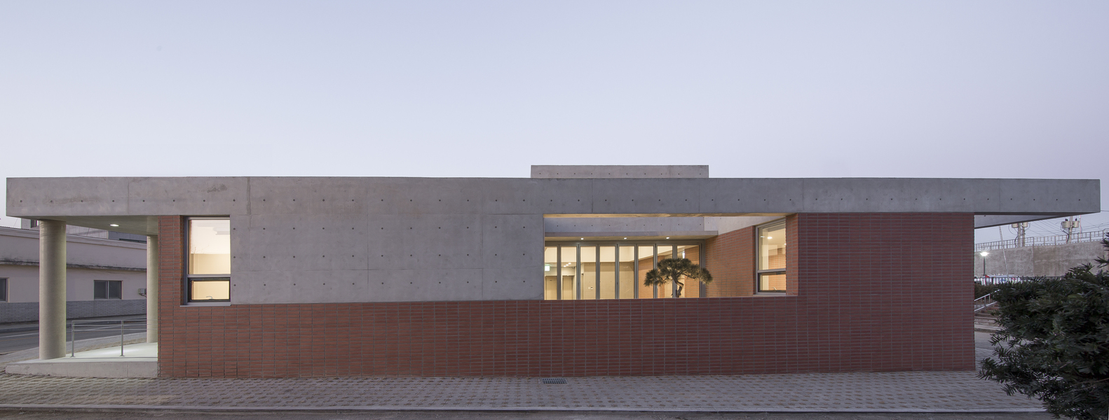Evening view of the facade with illuminated interior spaces visible through glazed openings
