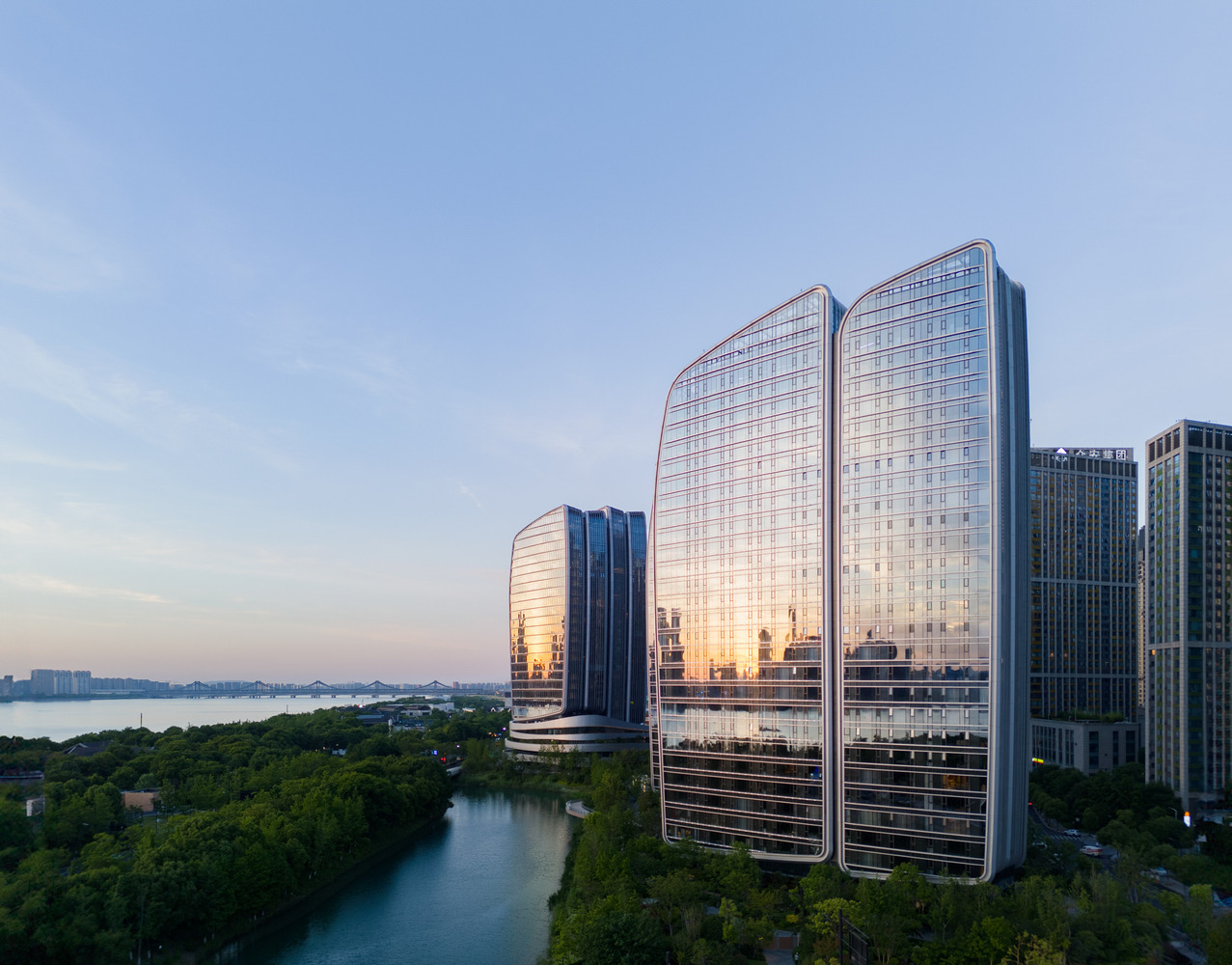 Towers reflected in the evening sky beside a landscaped waterway at dusk