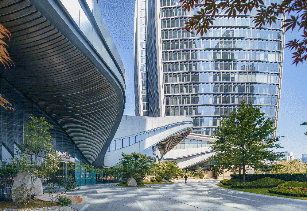Pedestrian pathway beneath cantilevered podium with slatted soffit and landscaped planting beds