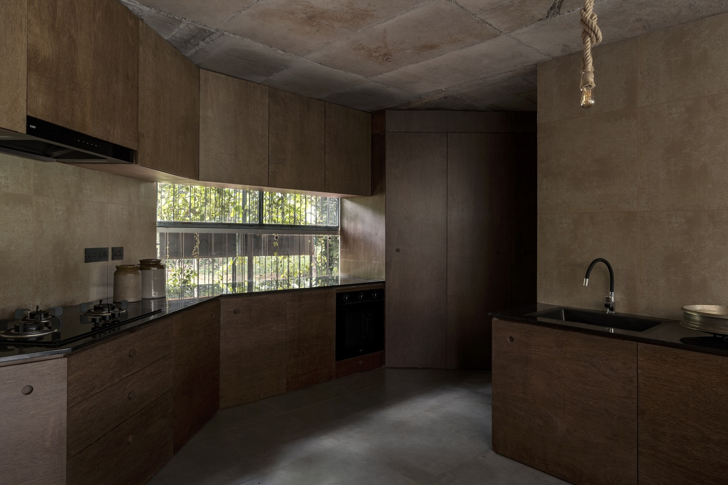Kitchen with timber cabinetry and horizontal window framing views of the courtyard greenery beyond