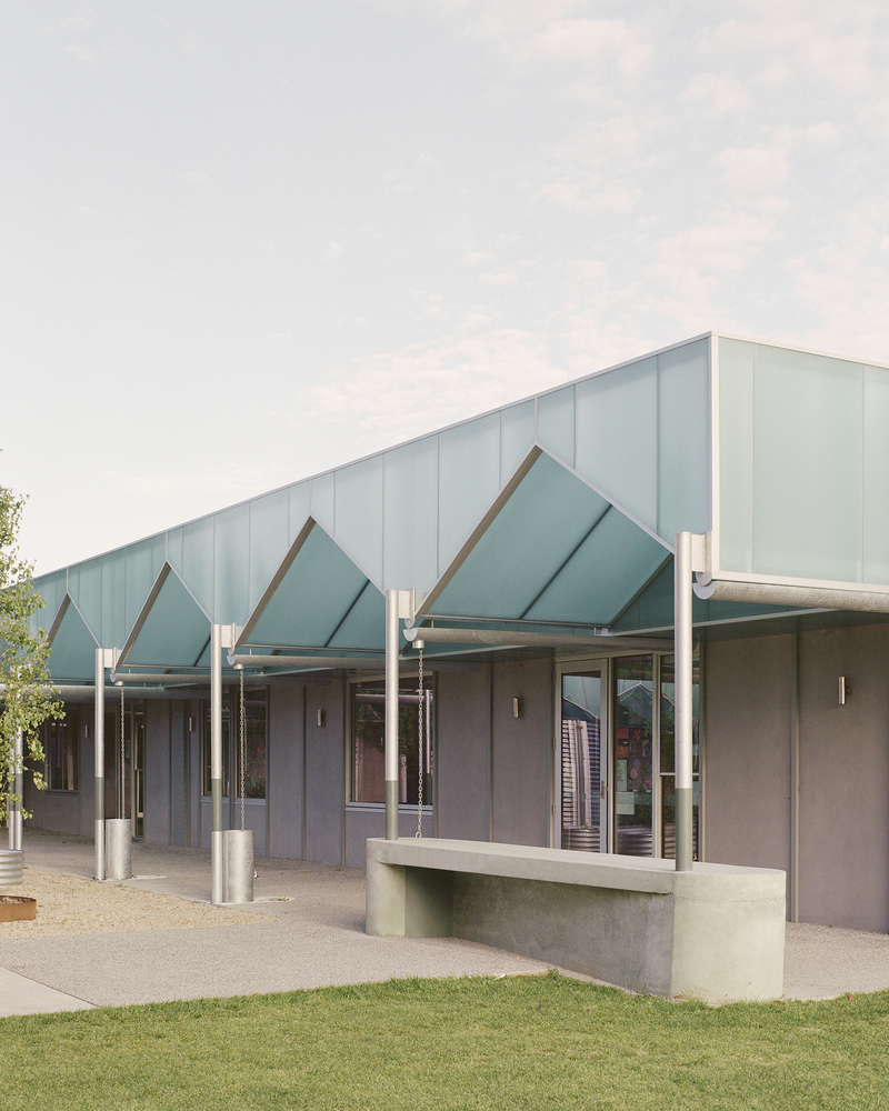 Exterior view of the sawtooth canopy with diagonal roof panels supported by circular steel columns