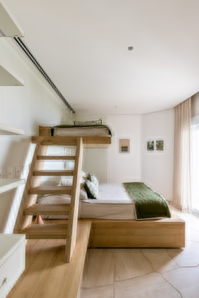 Bedroom with timber loft accessible by open-tread staircase and curved white walls
