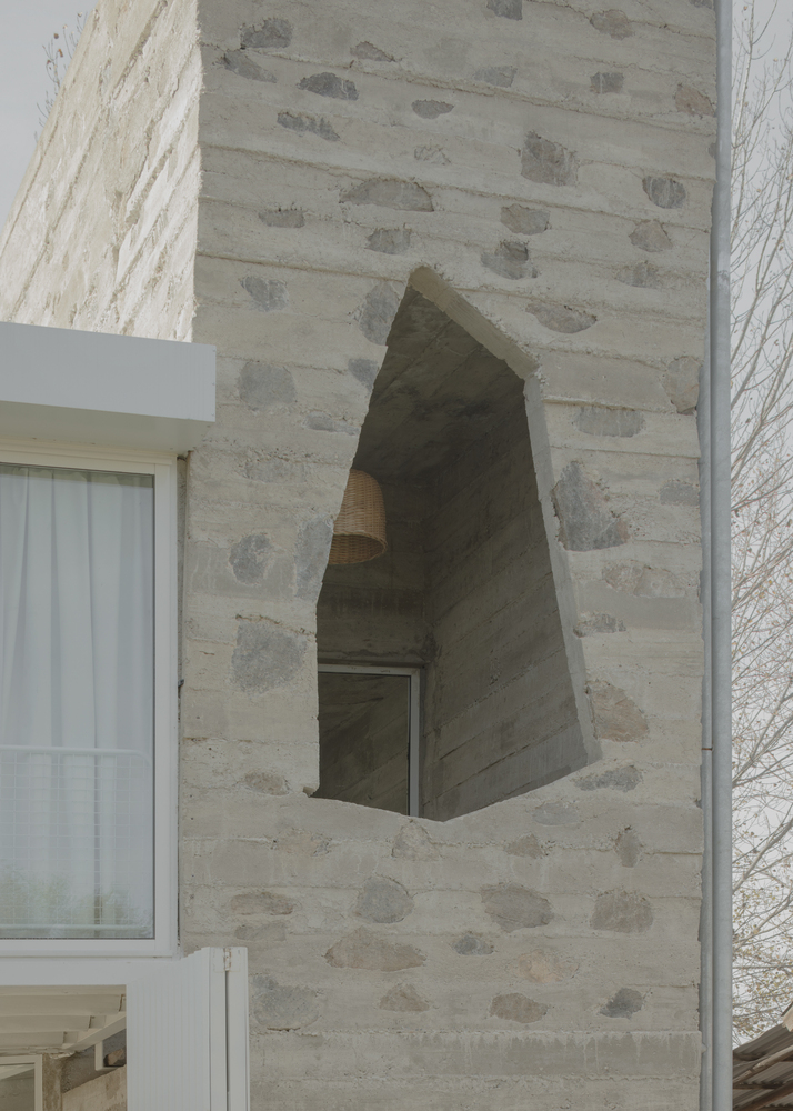 Tapered arched opening carved into the board-formed concrete tower wall