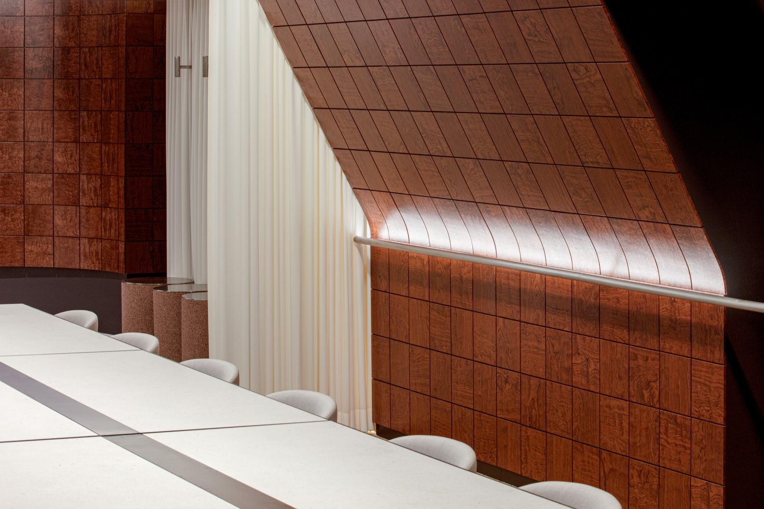 Angled red tile wall meeting white curtain with natural light streaming across the surface
