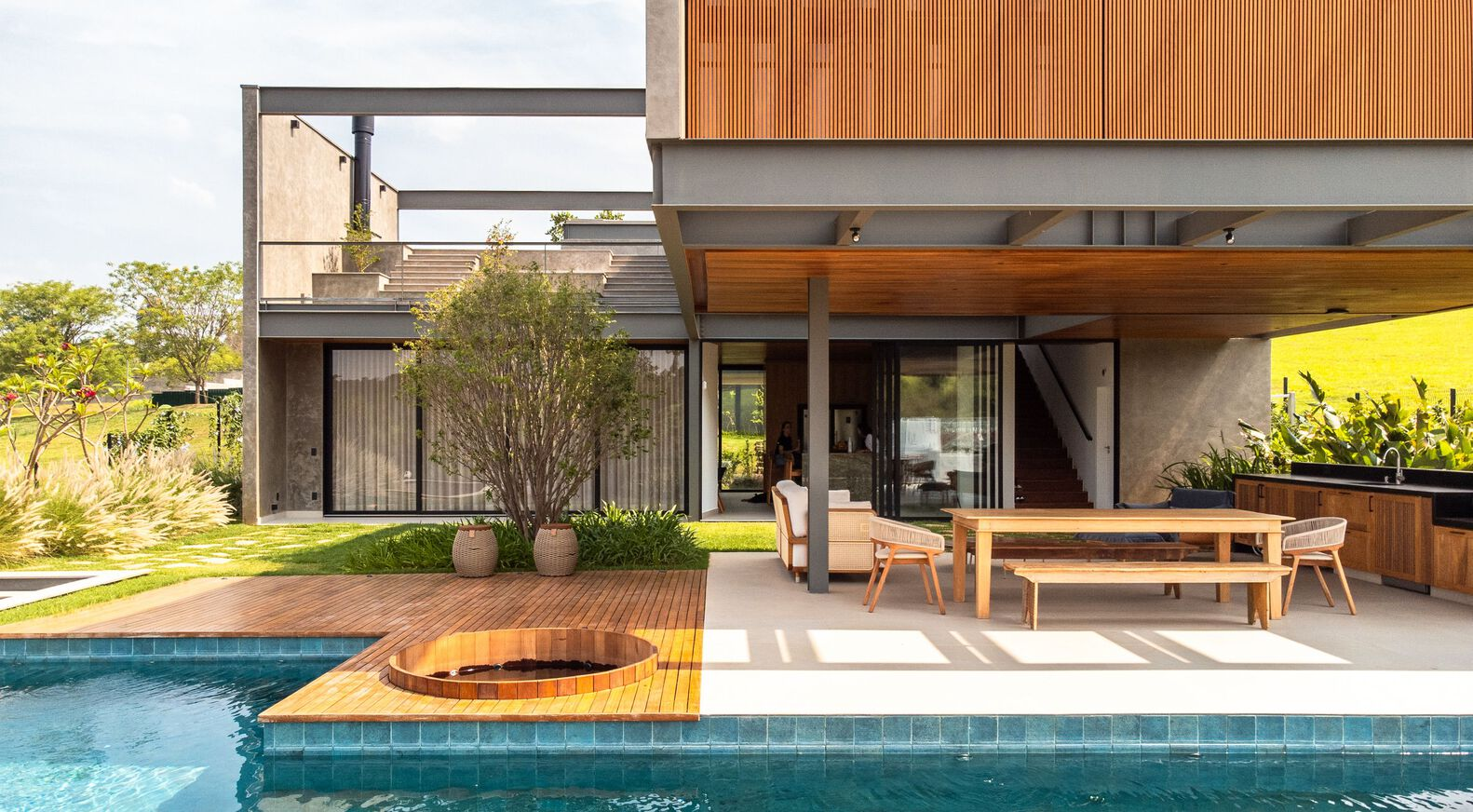 Pool terrace with timber deck and circular cutout looking toward wood-lined soffit and dining area
