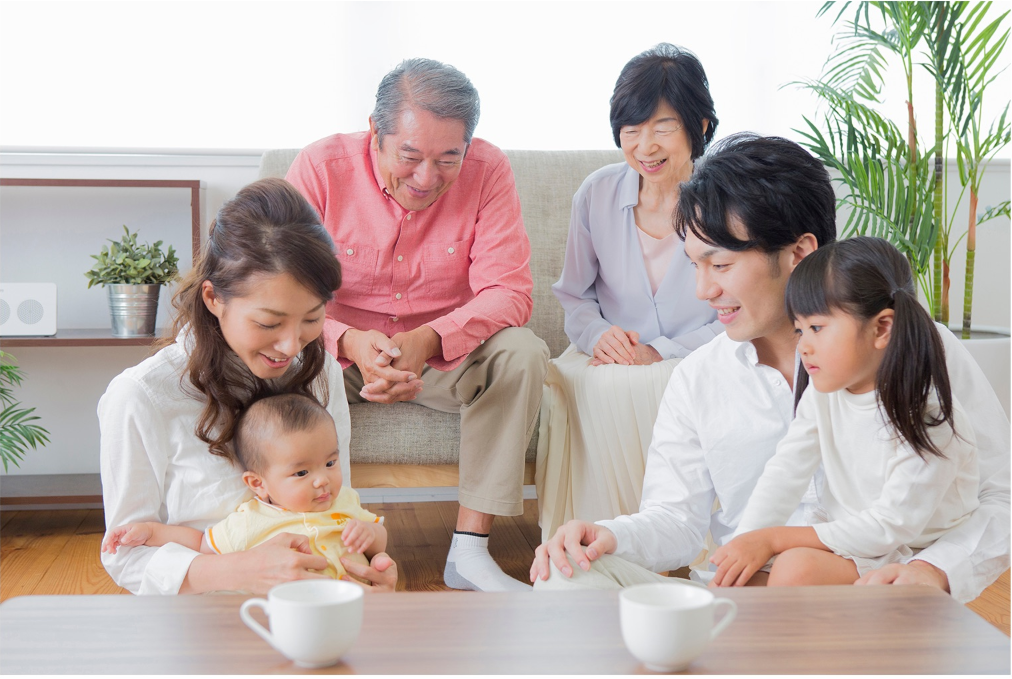 Living room with family gathered around a low table with potted palm in the corner