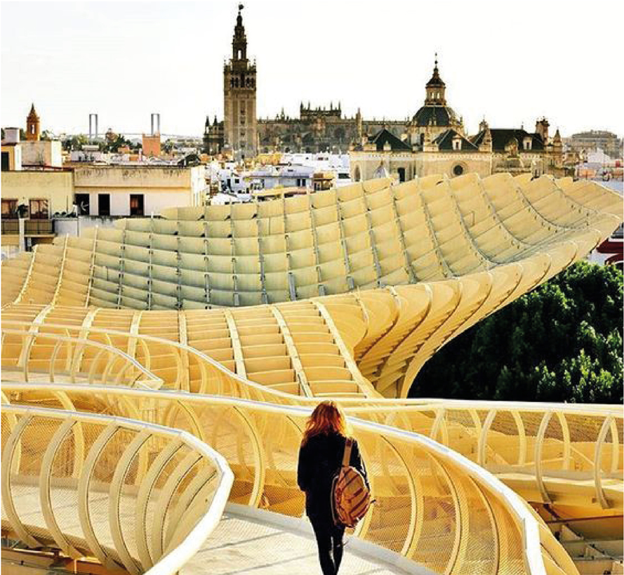Elevated walkway with undulating timber lattice canopy and a visitor overlooking the historic roofscape