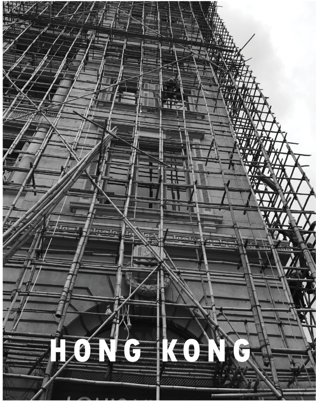 Dense vertical scaffolding redefines the urban facade, making construction a visible city layer.