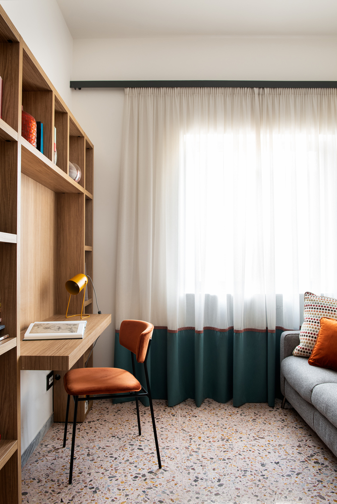 Study nook with timber shelving, built-in desk, and tricolor curtain panels filtering daylight