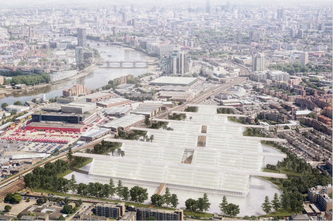 Aerial view of the white sawtooth-roofed industrial complex beside a river cutting through dense urban fabric