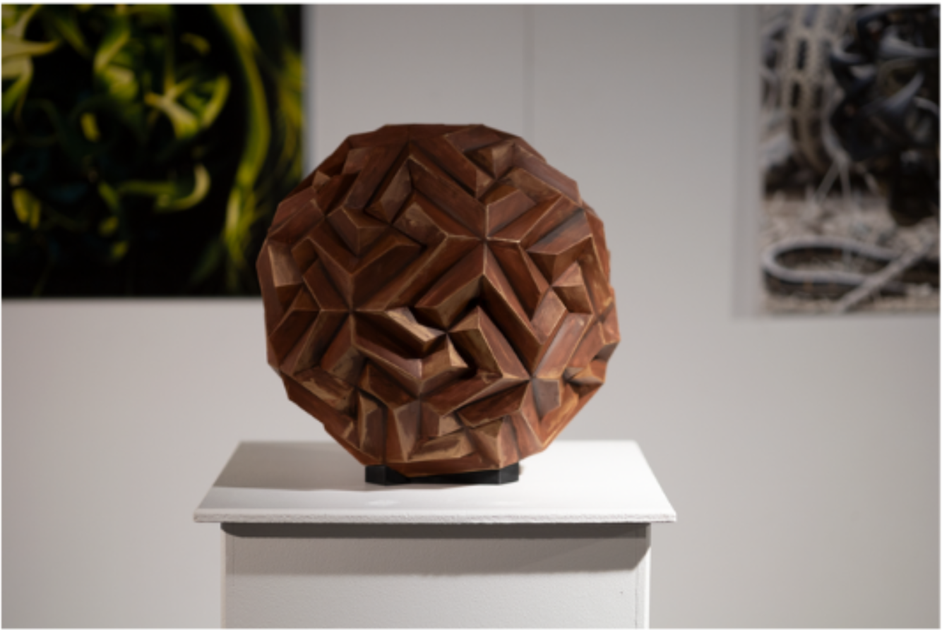 A richly textured brown polyhedron sculpture, combining geometry and organic craftsmanship.