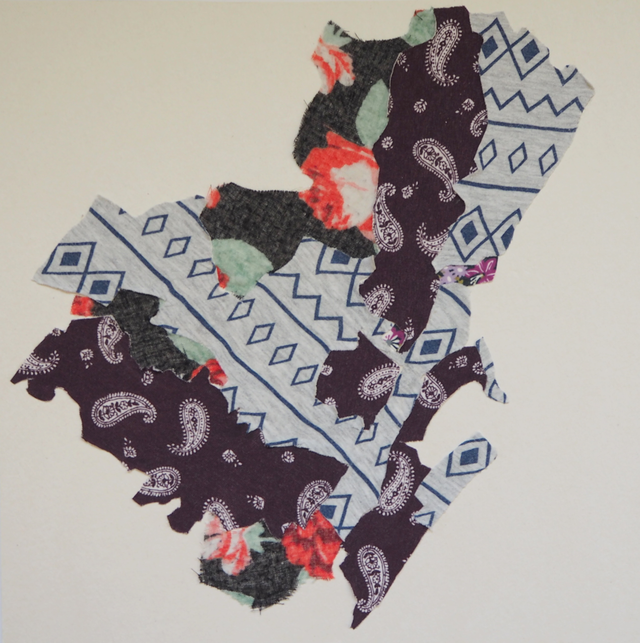 Collage of torn fabric samples with paisley and geometric patterns arranged on a beige background