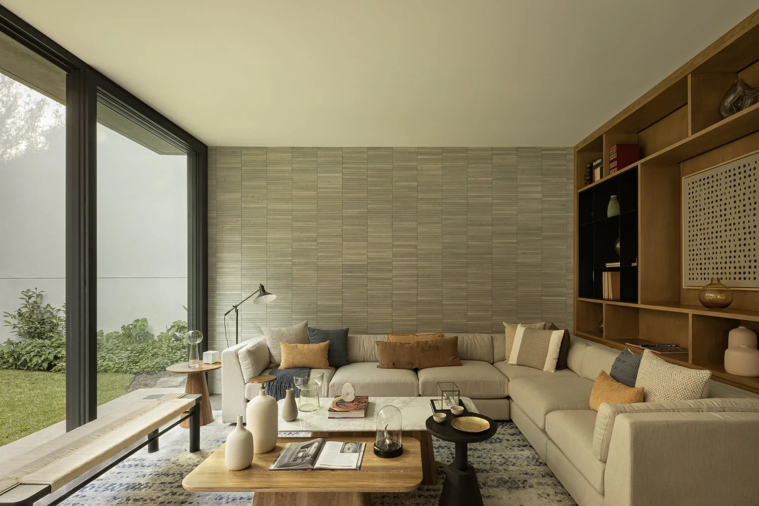 Living room with horizontal timber-clad wall and floor-to-ceiling glass opening to lawn