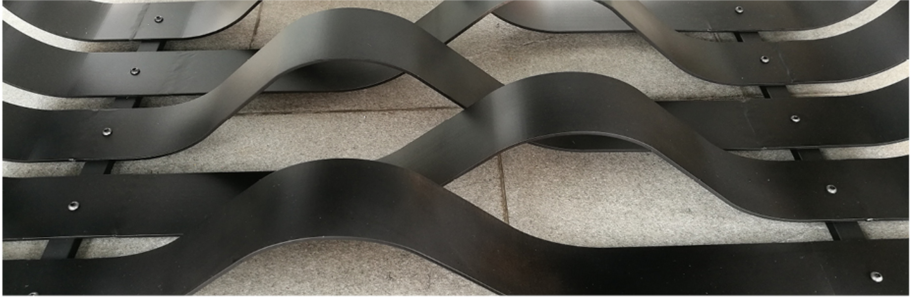Interwoven metal bands forming dynamic visual layers, emphasizing rhythm, repetition, and material precision.