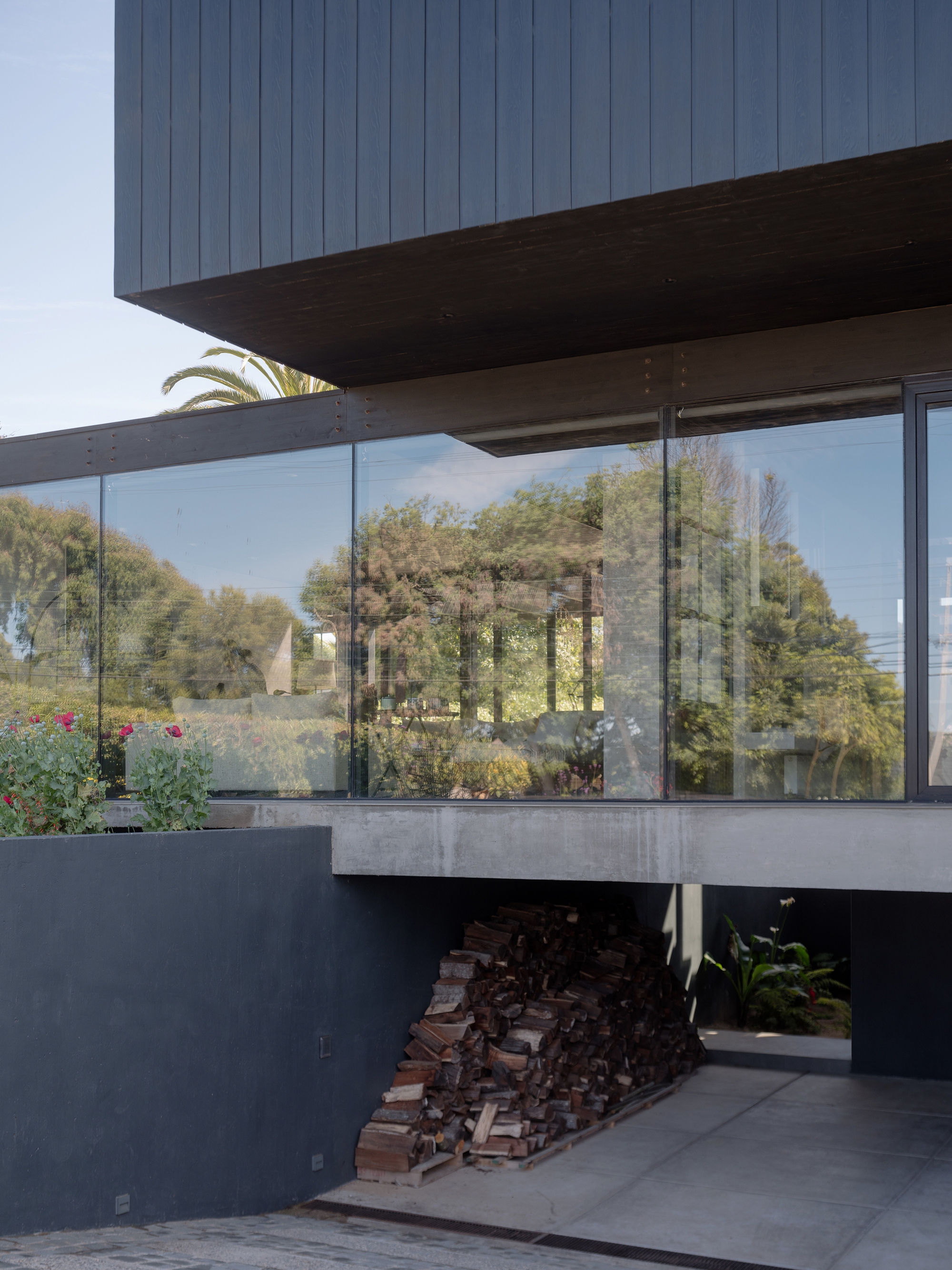 Glass-walled living level with views to surrounding trees and ocean beyond