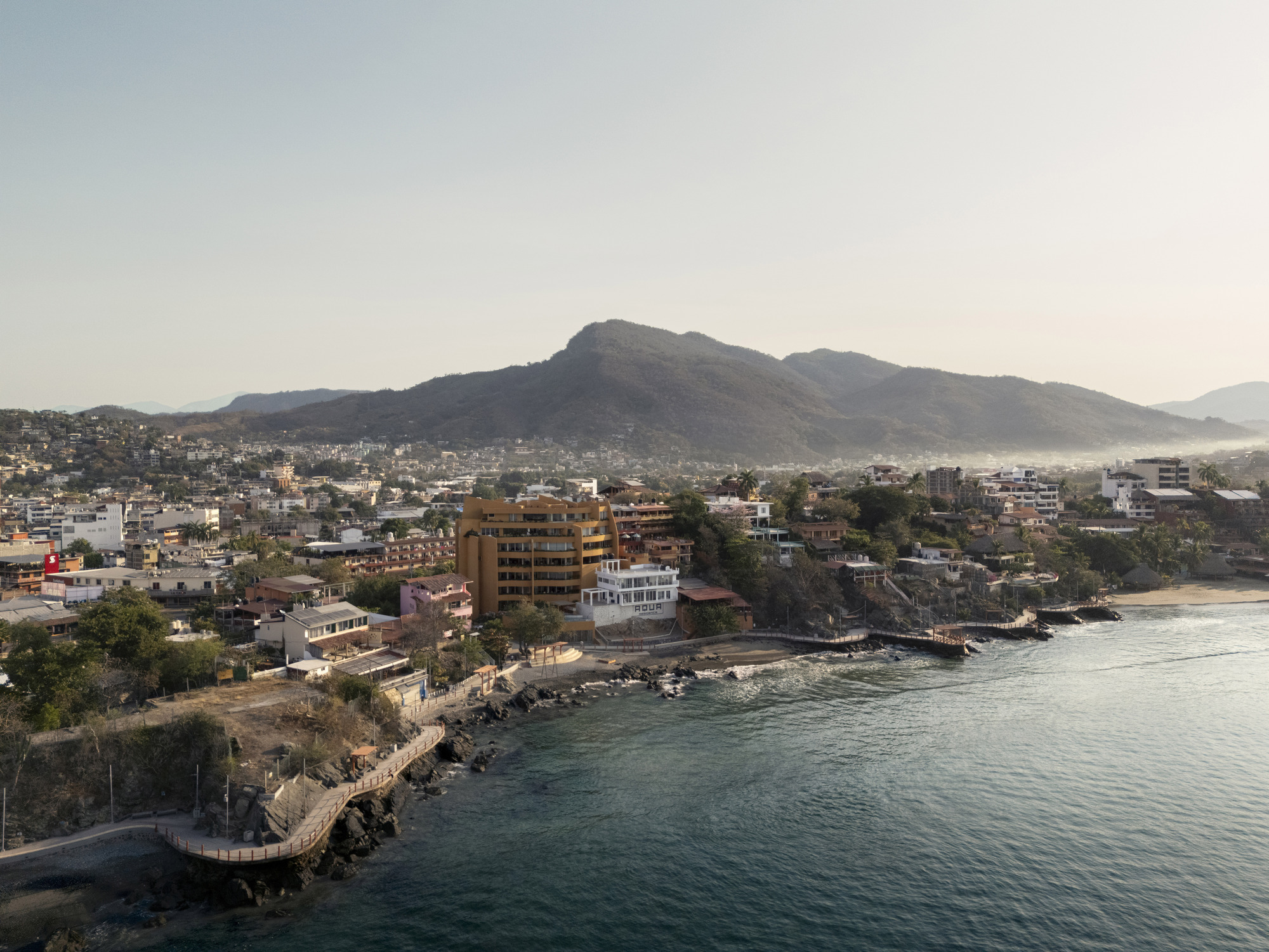 Aerial view of the coastal development with mountains in the distance at dusk