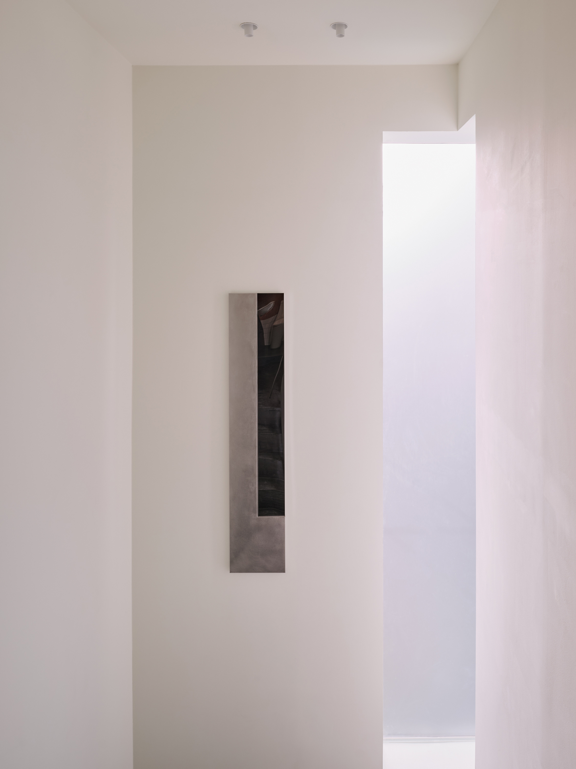 Close-up of the inset mirrored panel on the upper-floor wall