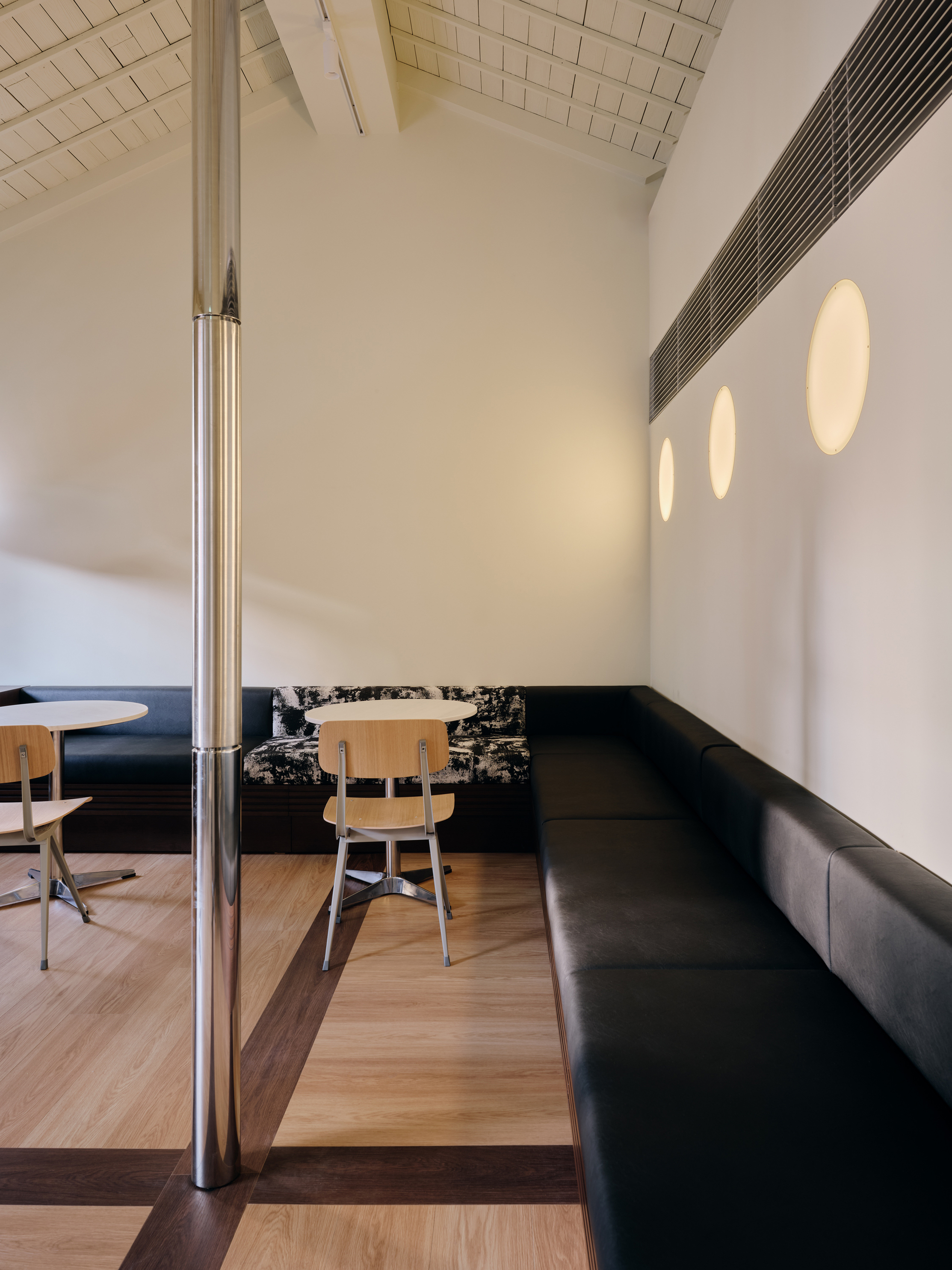 Long bench seating against a wall with three circular wall lights