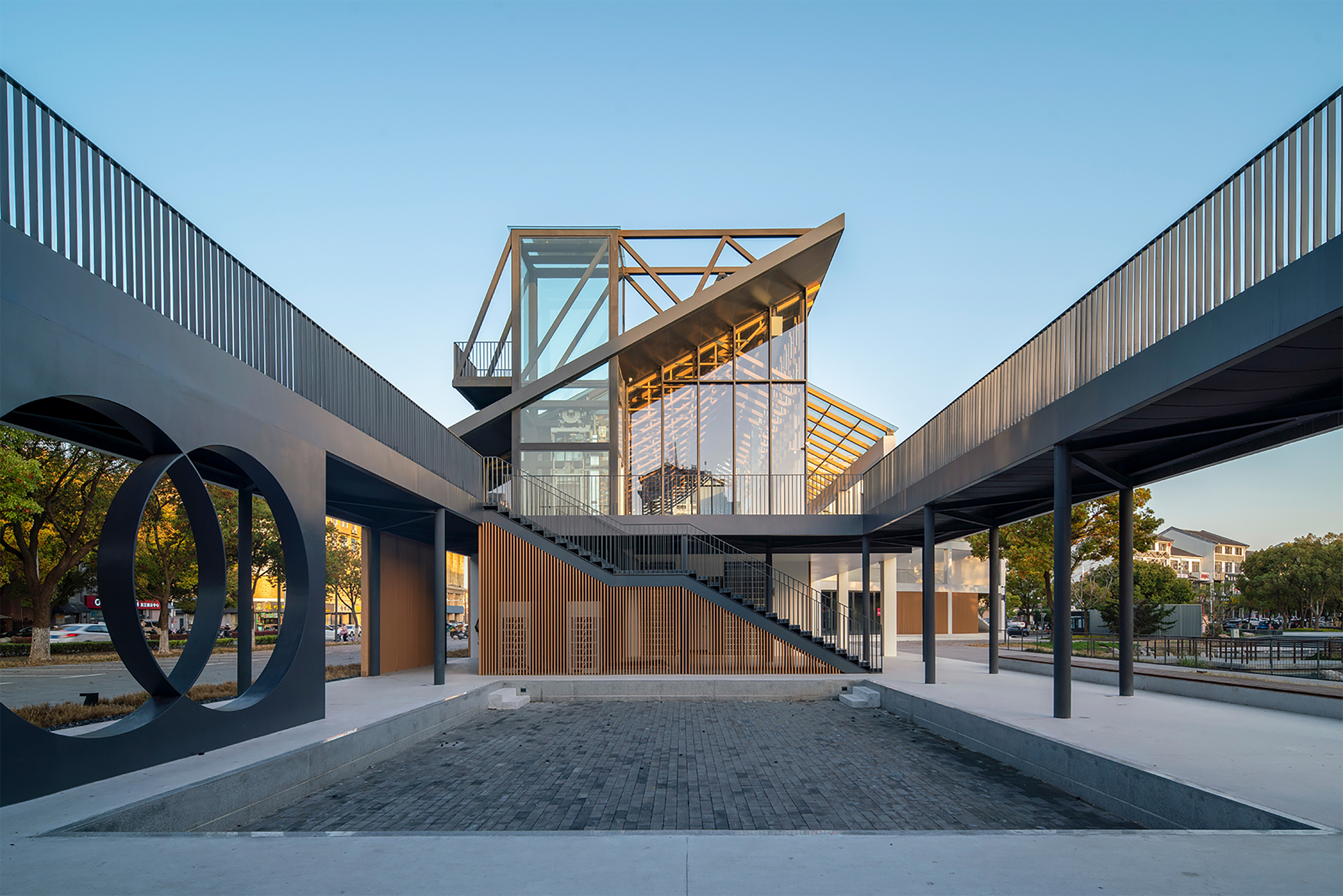View through the covered walkway framing the elevated timber structure at dusk