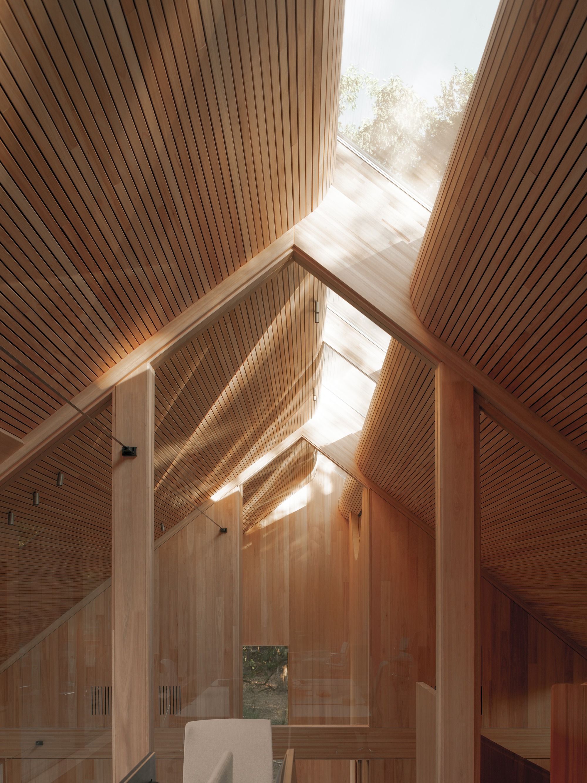 Upward view of the vaulted timber ceiling with clerestory windows bringing in afternoon light