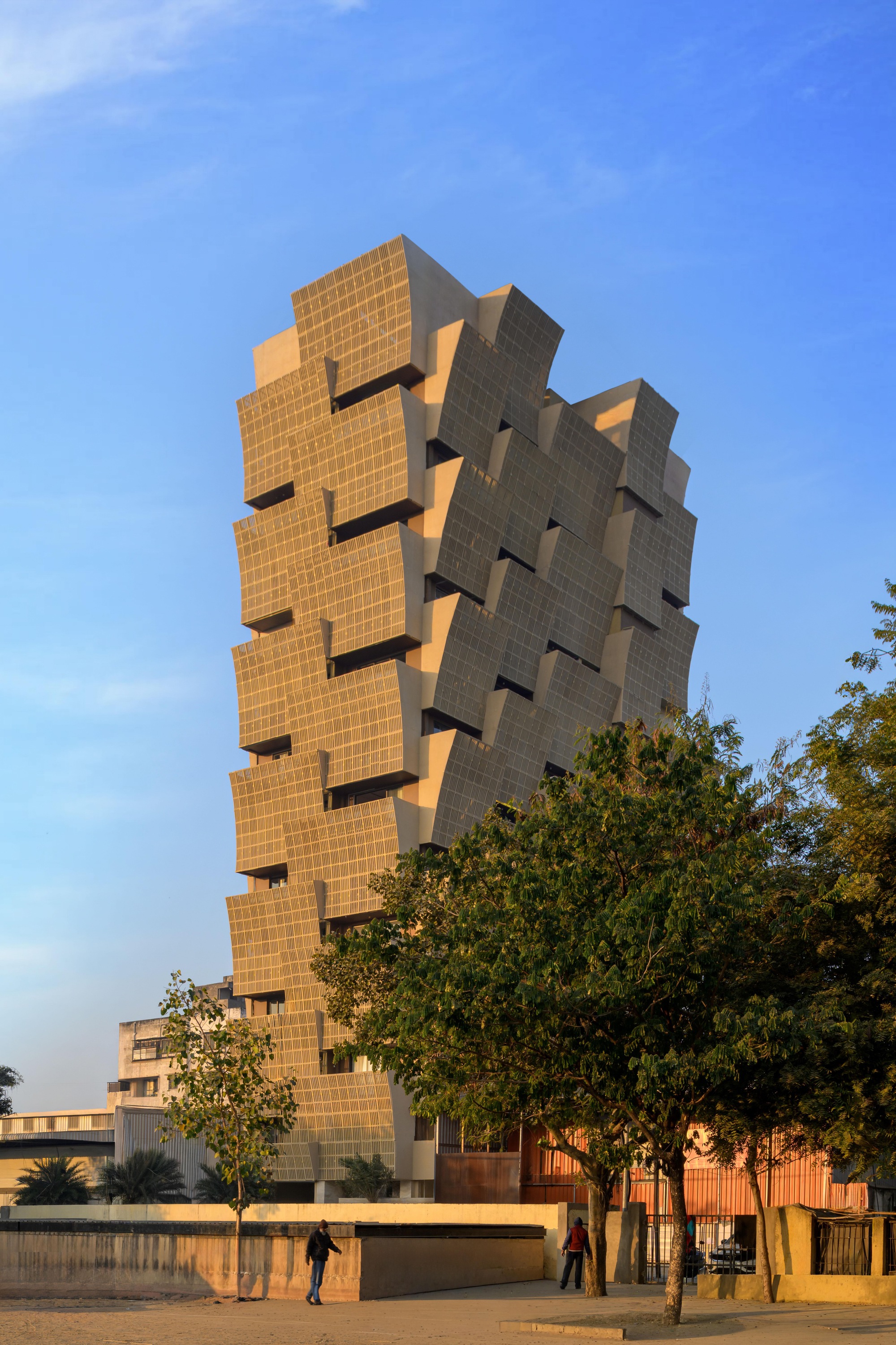Street view of the offset brick facade with pedestrians walking along the perimeter wall