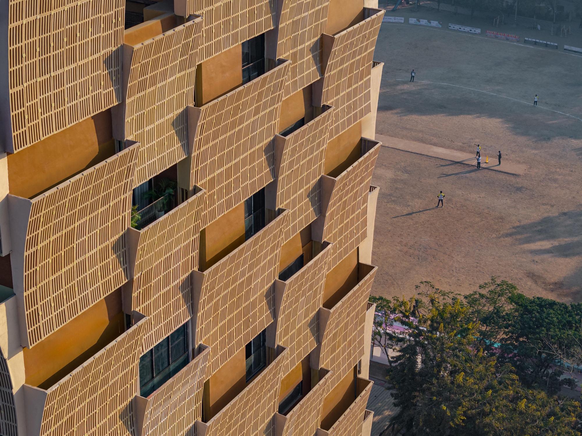 Aerial view of the protruding brick screens with figures on the paved ground below