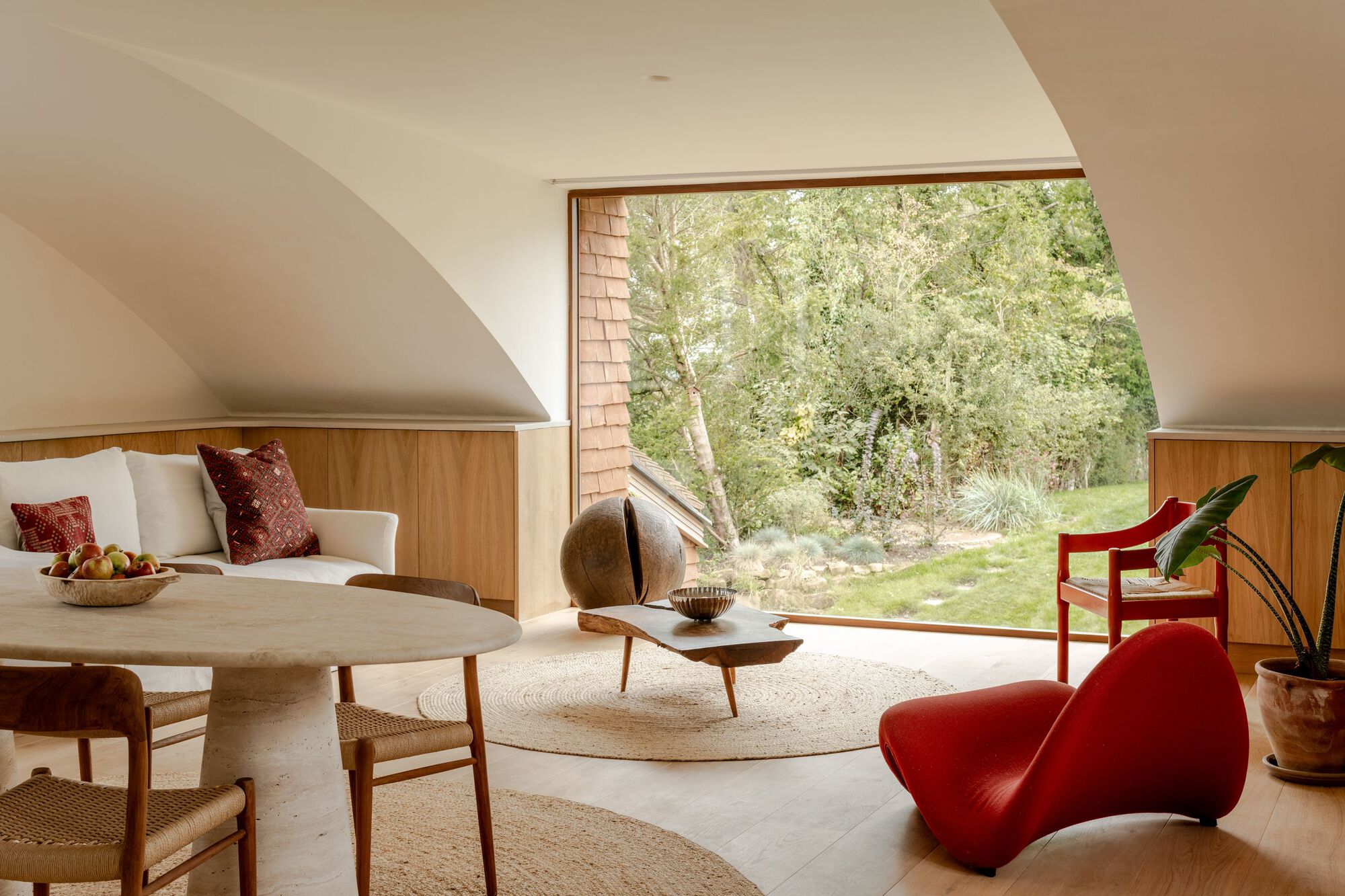Living room with corner picture window framing birch trees and garden beyond