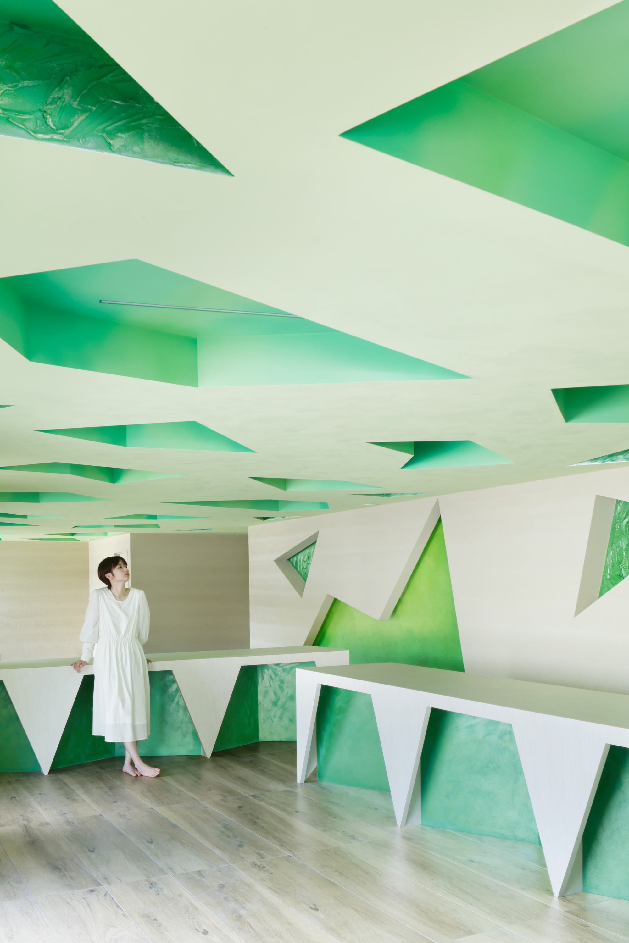Counter detail with sharp angled white forms set against the green-toned interior