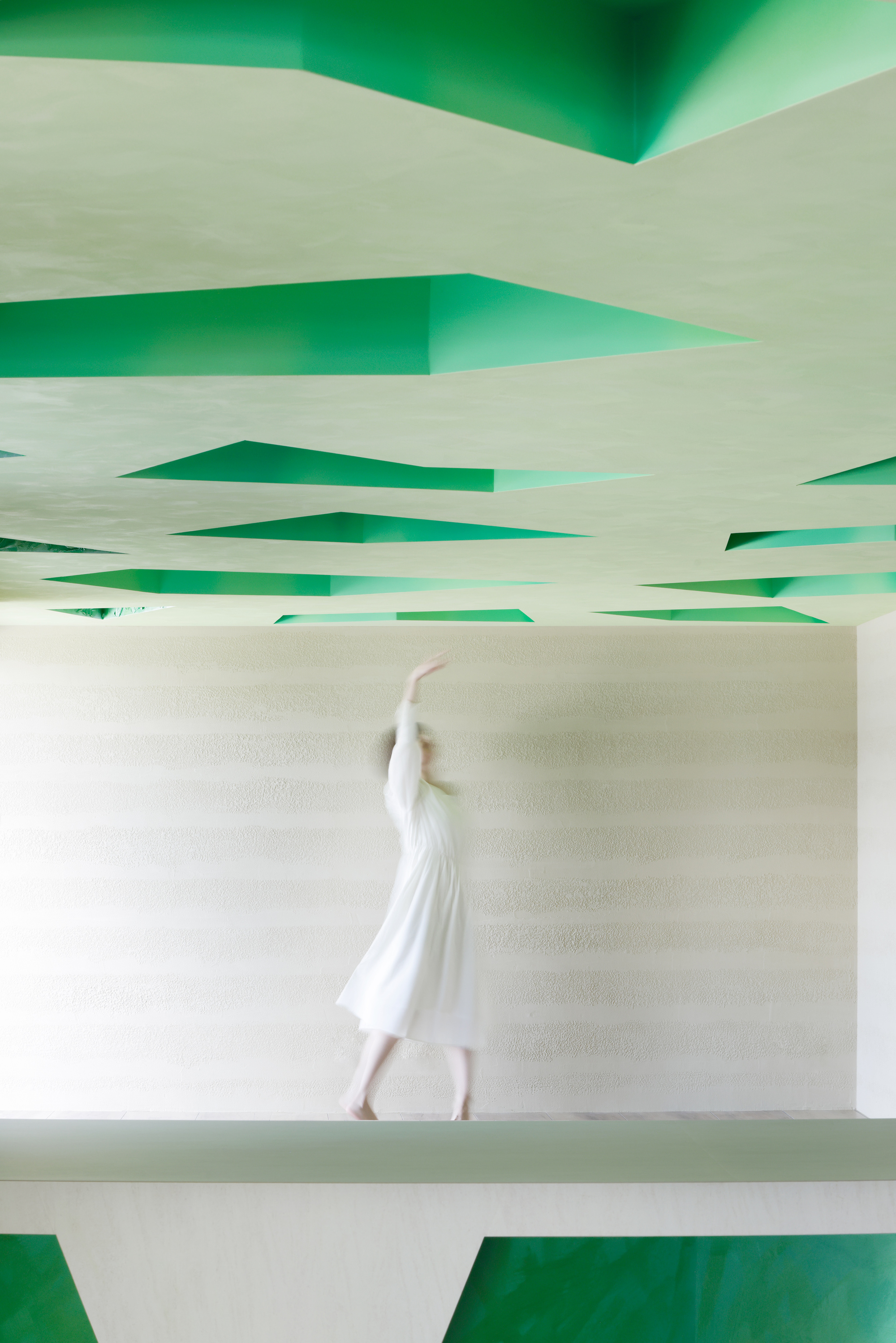 Motion-blurred figure walking past the carved-out ceiling and a sculpted bench