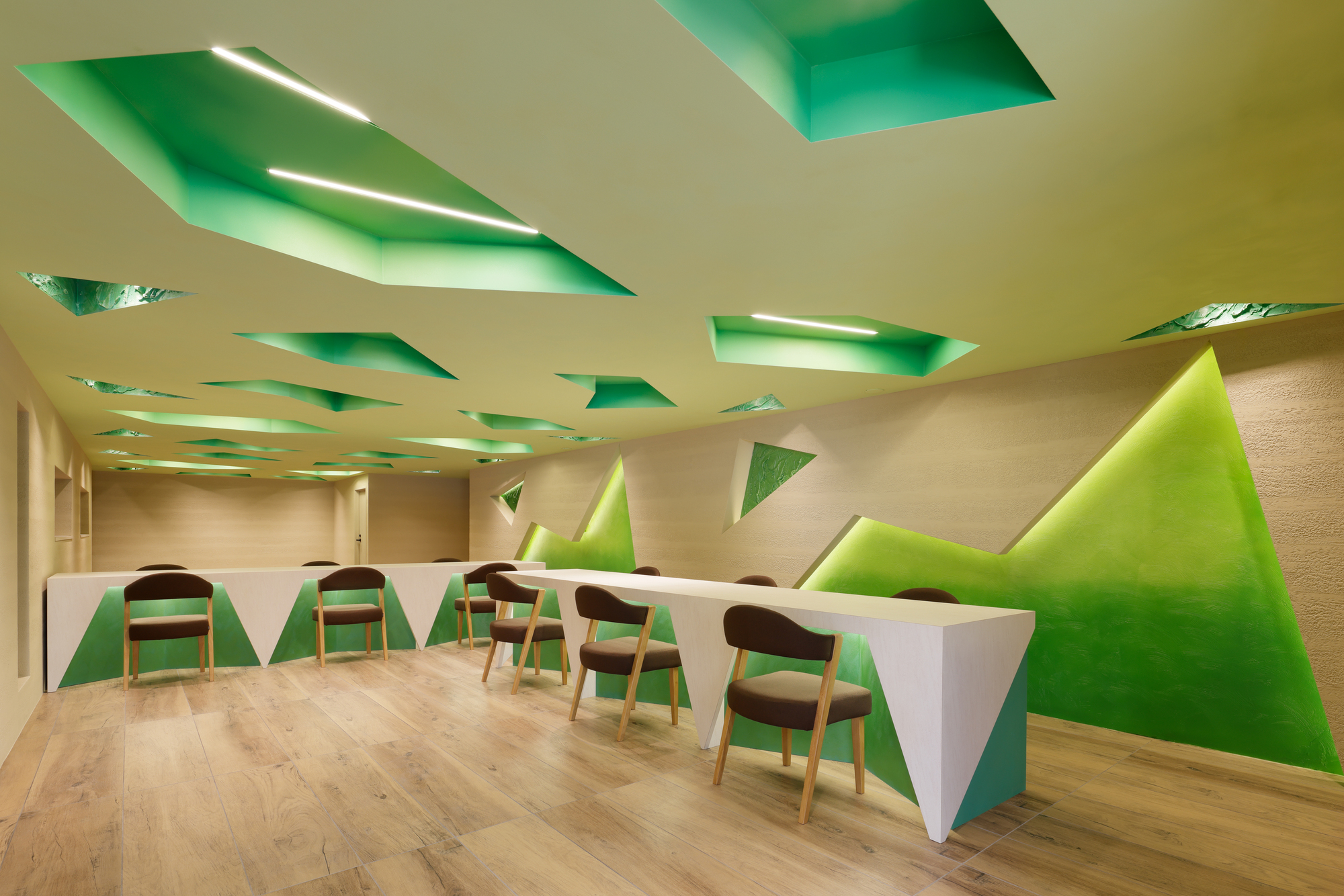 Long meeting room with chairs lined along a sculpted desk under the patterned ceiling