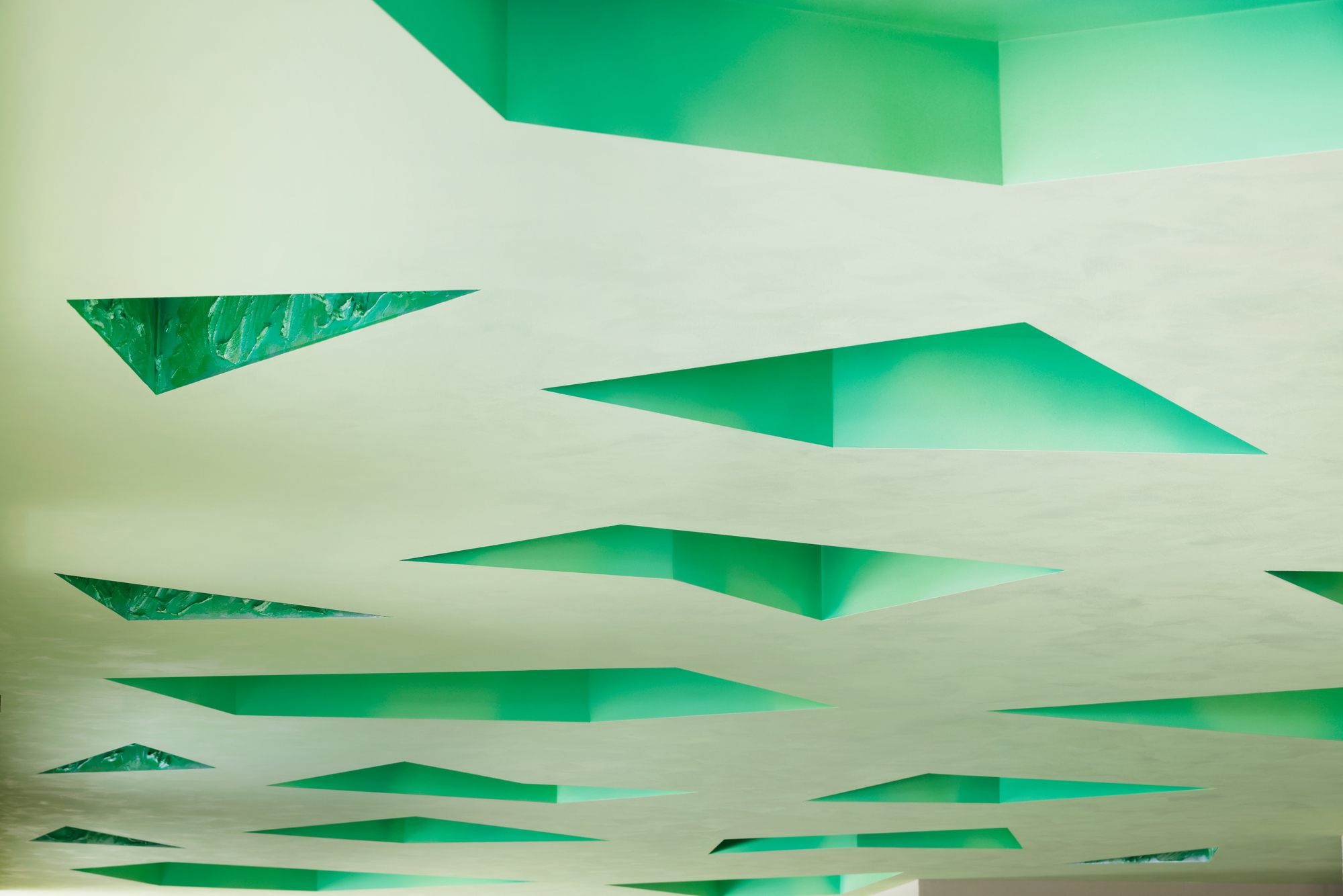Looking up at the ceiling cavities painted in saturated green from below