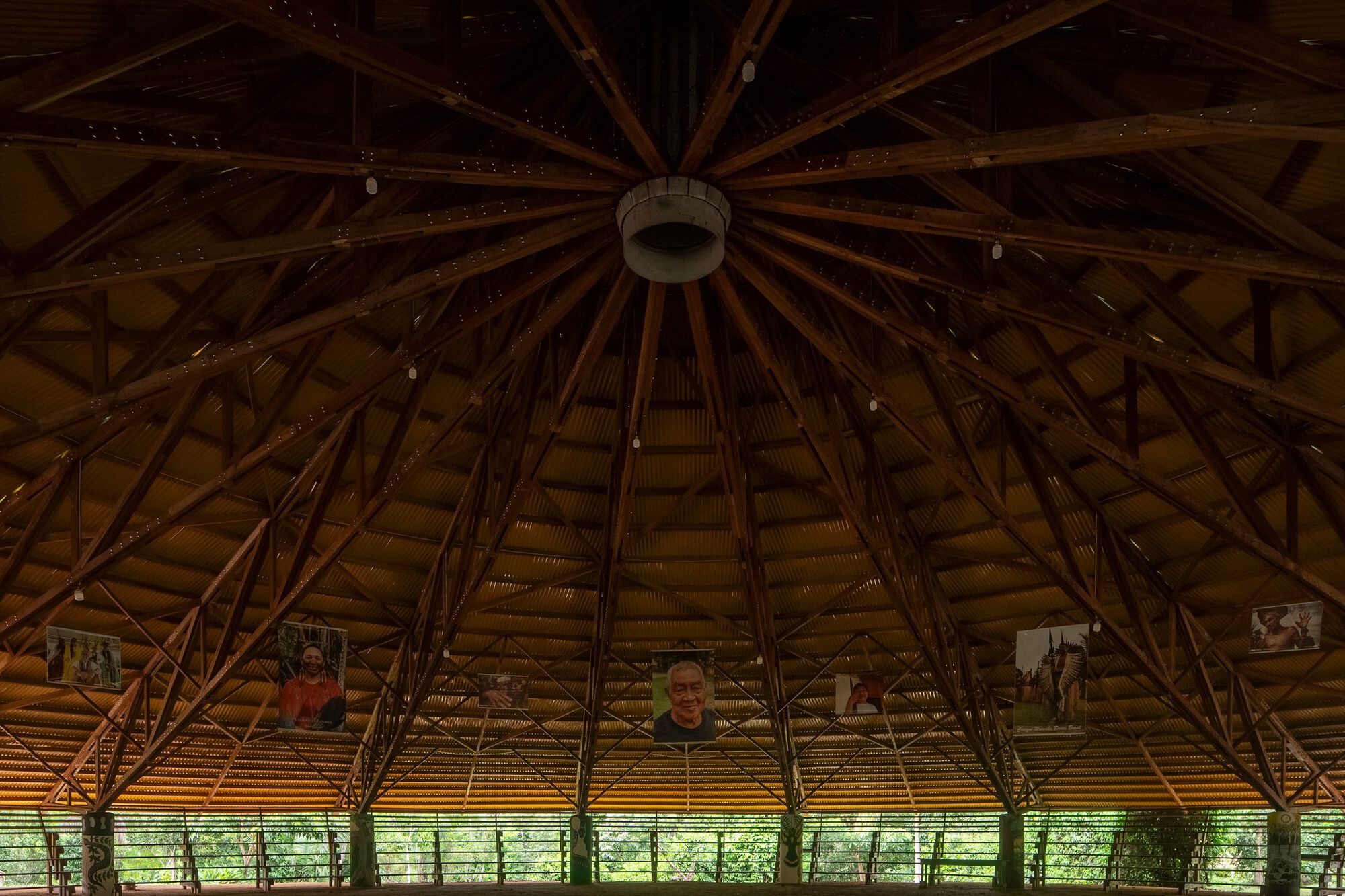 Upward view of radial timber roof structure with central oculus and woven bamboo ceiling panels